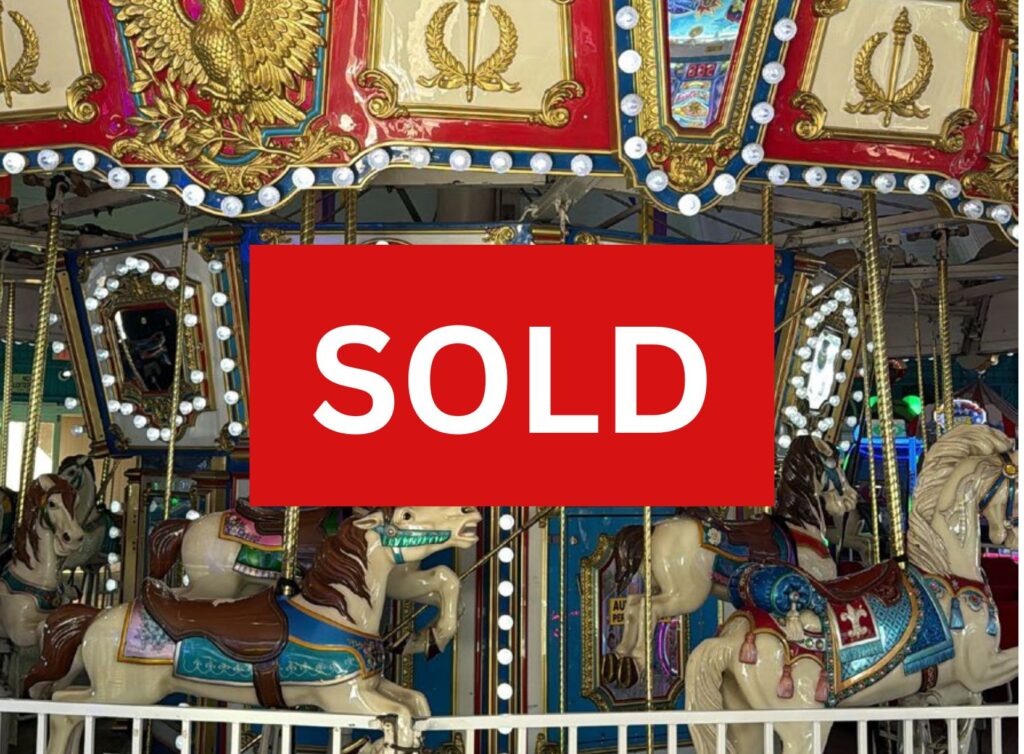 Colorful carousel with ornate gold trim and illuminated bulbs, overlaid by a red 'SOLD' banner.